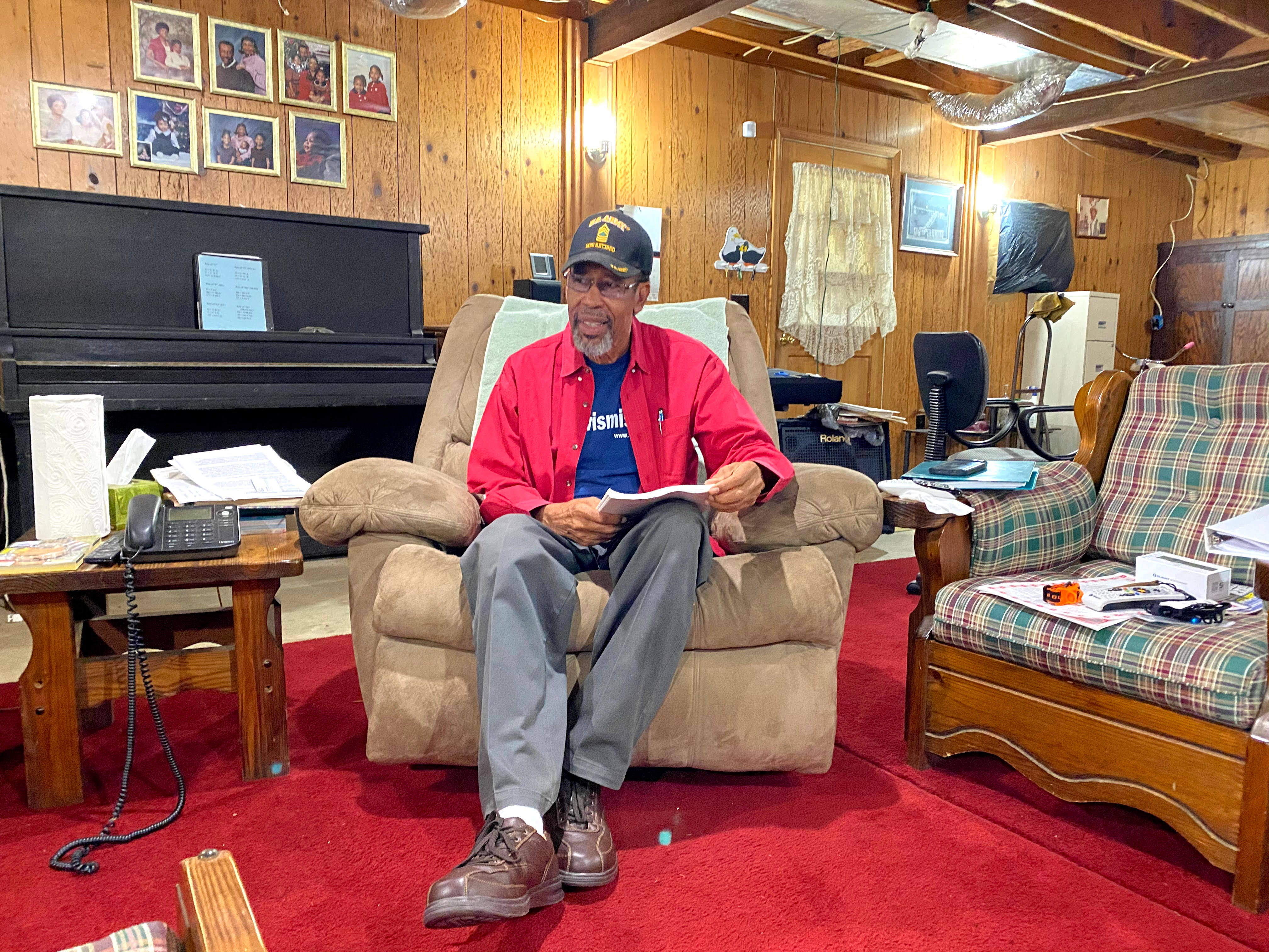 A man sits in a recliner chair in his home