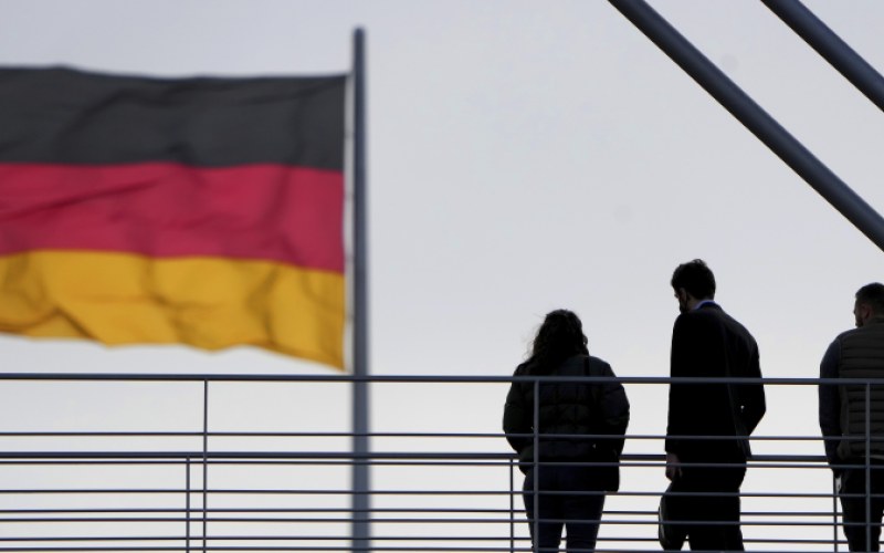 People stay on a pedestrian bridge between two parliament buildings in Berlin, Germany, Monday, Jan. 3, 2022. (AP Photo/Michael Sohn)