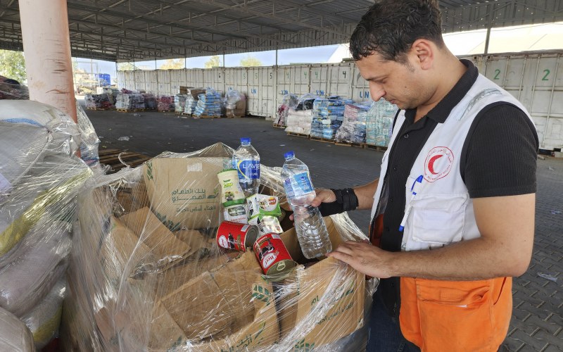 United Nations and Red Crescent workers prepare the aid for distribution to Palestinians at UNRWA warehouse in Deir Al-Balah, Gaza Strip, on Monday, Oct. 23, 2023.