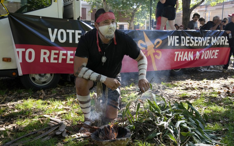 Aboriginal man Josh Sly of the Muggera Dancers prepares a fire for a smoking ceremony at the start of an Invasion Day rally in Sydney, Australia