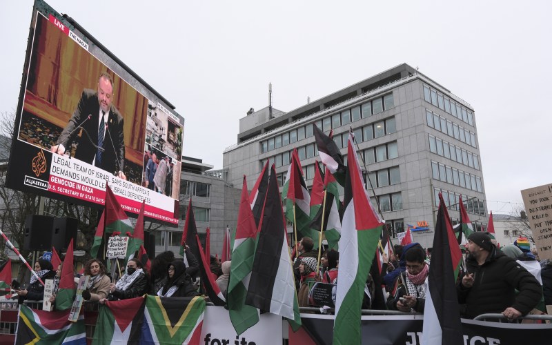  people holding flags in front of a big projector screen