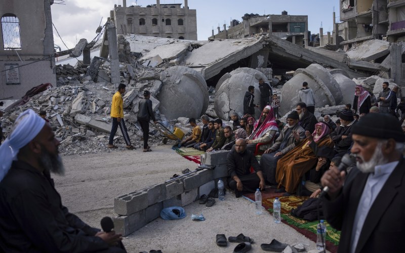 people praying by rubble