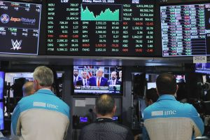 Traders at the New York Stock Exchange watch President Trump