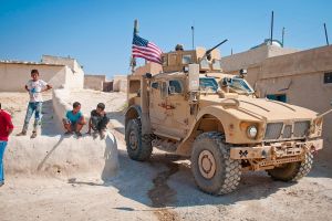 Children gather around a U.S. tactical vehicle in Syria