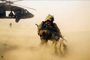 A US soldier in Afghanistan, with sand blowing in the foreground