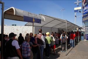 People wait in line at the US-Mexico border. 