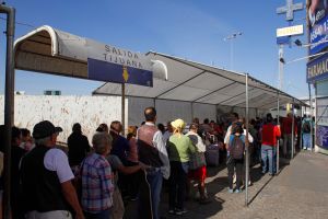 People wait in line at the US-Mexico border. 