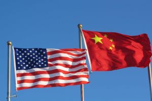 USA and China flags in front of a blue sky