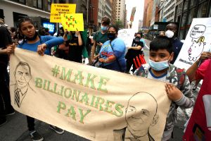 Children protesting and holding a sign that says "Make Billionaires Pay."