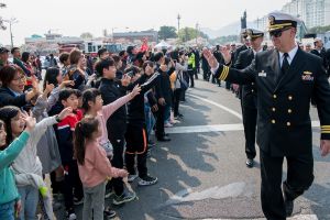 Sailors wave to children while marching in the annual Jinhae Gunhangje military port festival parade in South Korea, April 5, 2019.