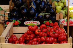 A vegetable stand with prices written in Italian at a market