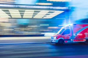 An ambulance drives with lights on