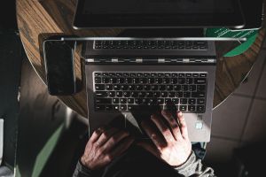 View of a person's hands typing on a laptop