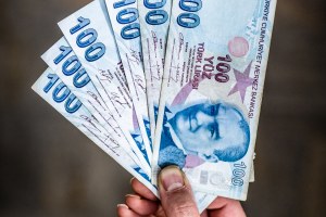 A person holds six hundred Turkish Lira banknotes