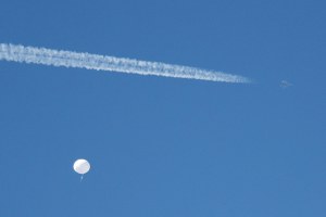 A jet flies by a suspected Chinese spy balloon as it floats off the coast in Surfside Beach