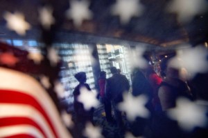 people are seen through an American flag