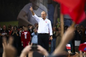 Opposition leader Donald Tusk, center, flashes a victory sign as he speaks.