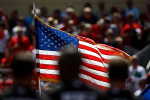 a crowd stands for the national anthem