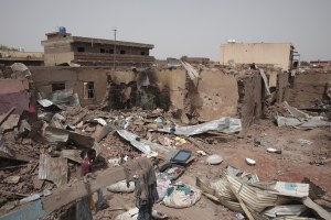 A man walks by a house hit in recent fighting in Khartoum, Sudan