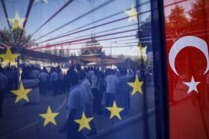 People are seen behind a European Union and a Turkish flag