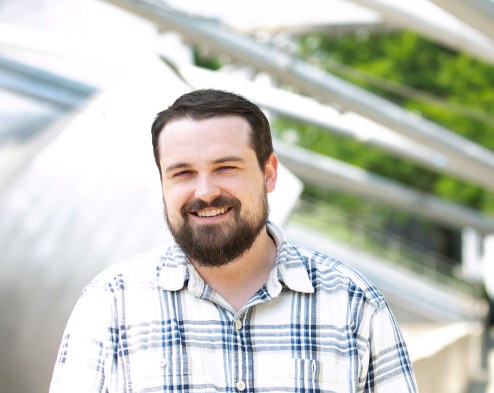 Council expert AJ Caughey is pictured outside in a plaid shirt looking into the camera smiling