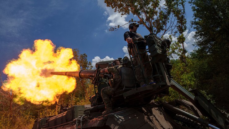 Ukrainian soldiers fire by 2s7 self-propelled howitzer towards Russian positions