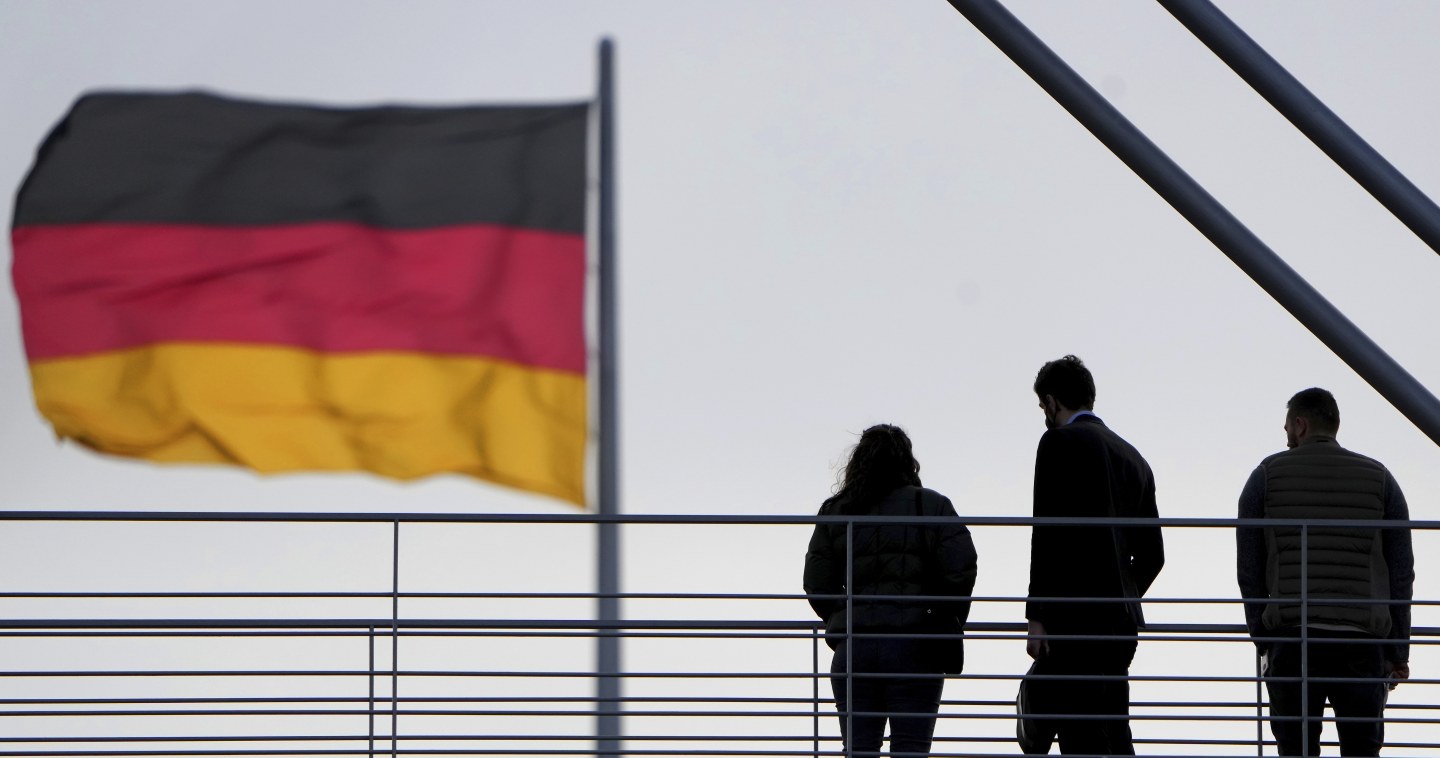 People stay on a pedestrian bridge between two parliament buildings in Berlin, Germany, Monday, Jan. 3, 2022. (AP Photo/Michael Sohn)