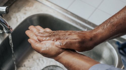 A person washing their hands in a sink