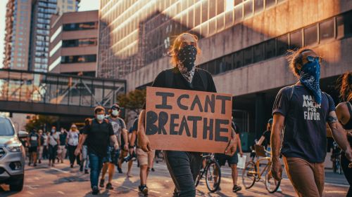 A person carrying a sign saying "I can't breathe" walks through Minneapolis during protests