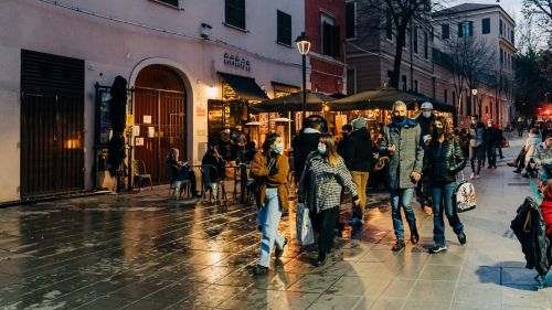 People walking through a city market, wearing face masks