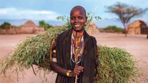 A young woman from the Erbore tribe in Ethiopia carries grasses.