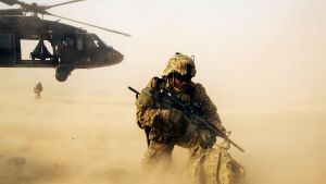 A US soldier in Afghanistan, with sand blowing in the foreground