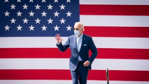 President Elect Biden waves in front of US flag. 