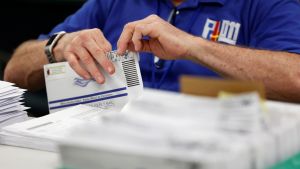 A man opening ballots from the 2020 election. 