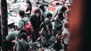 People wearing masks go to a market 