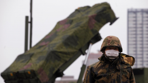 A member of the Japan Self-Defence Forces stands guard in front of Patriot Advanced Capability-3 (PAC-3) land-to-air missiles, deployed at the Defence Ministry in Tokyo