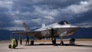 An F35A fighter jet, with a dark cloudy sky in the background