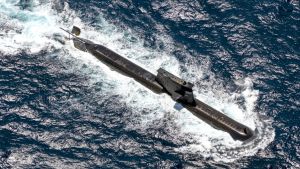 A breached submarine traveling above the water's surface.