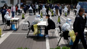 People sit at tables while getting tested for COVID-19