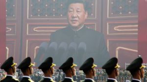 Soldiers of People's Liberation Army (PLA) are seen before a giant screen as Chinese President Xi Jinping speaks