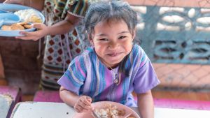 A girl enjoys a meal in school