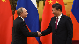 Against a backdrop of Russian and Chinese flags, Russian President Vladimir Putin shakes hands with Chinese President Xi Jinping at the end of a joint press briefing in Beijing's Great Hall of the People.