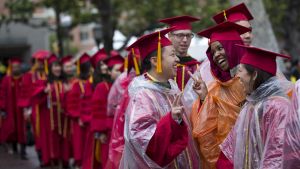 A group of people in red graduation caps and gowns