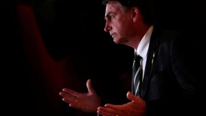 Jair Bolsonaro speaking onstage during a forum in Brazil