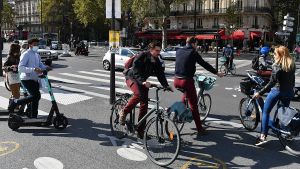 A group of people on bikes wait at a crosswalk