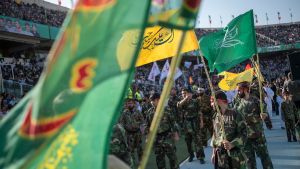 People hold flags during the gathering of one hundred thousand supporters of Iran's Supreme Leader