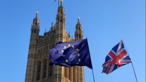 The European Union and United Kingdom flags with the House of Commons in the background