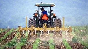 A man plows a field using a tractor.