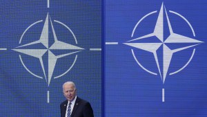 Biden stands in front of the NATO flag