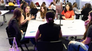 Nicole speaks at a table with girls. 